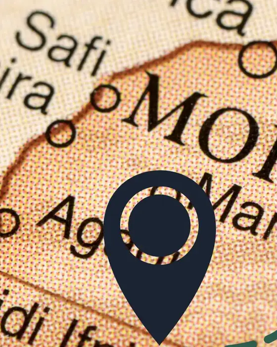An old map of southern Morocco with a dark pin dropped near Marrakech