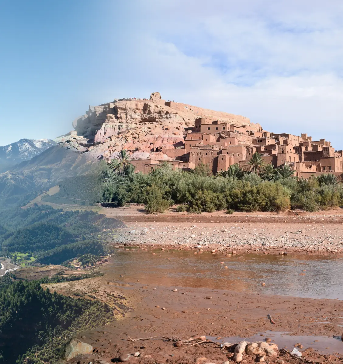 The earthen kasbah of Aït Benhaddou above a stony riverbed