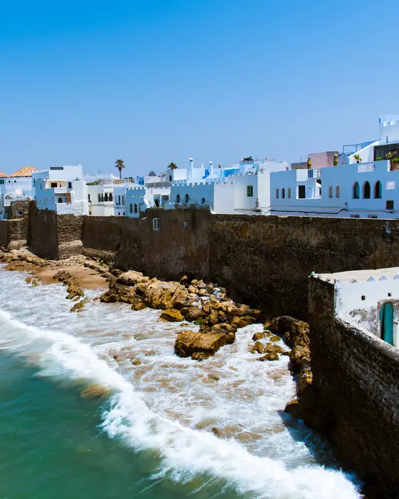 The white houses of Asilah above the old sea wall, with Atlantic waves breaking on the rocks