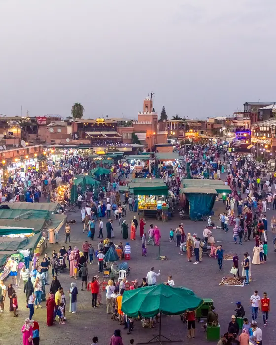 Jemaa el-Fnaa square in Marrakech at dusk, busy with food stalls and people