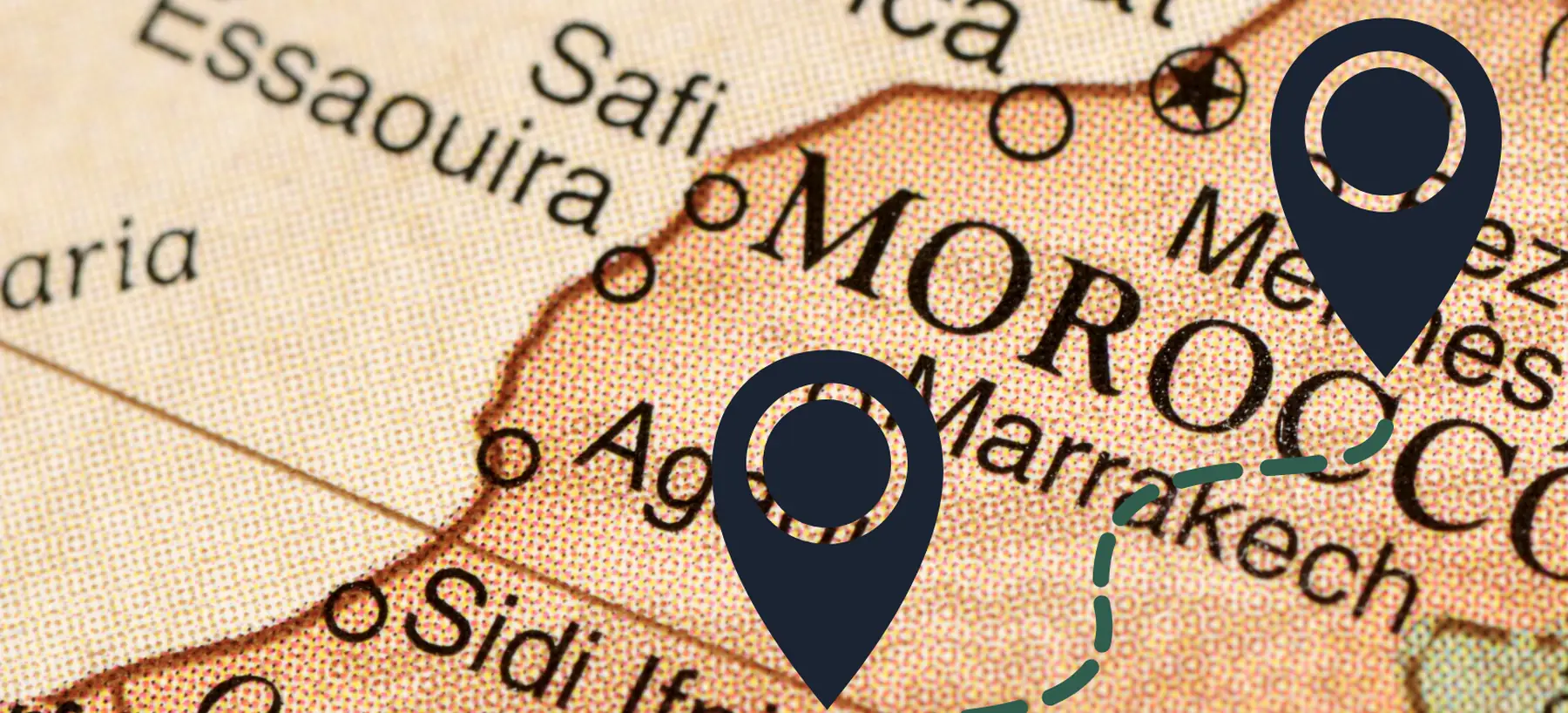 An old map of Morocco with two pins and a dashed route drawn between them